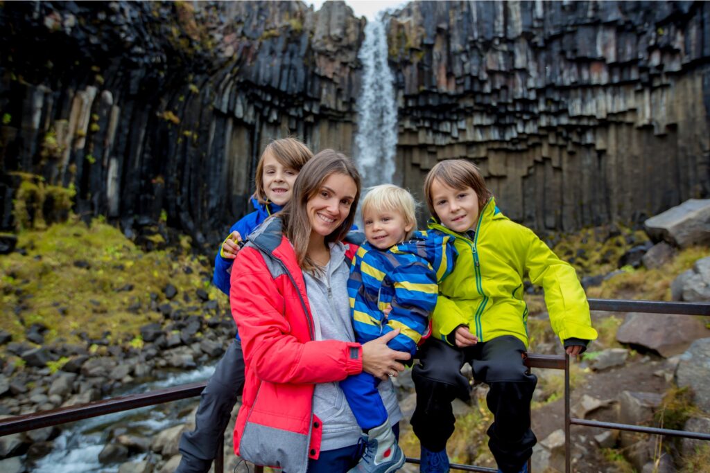 Family; mother and children, in front of a waterfall